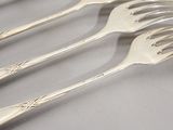 four forks that are sitting next to each other on a table