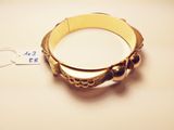 a gold bracelet that has been placed on a table