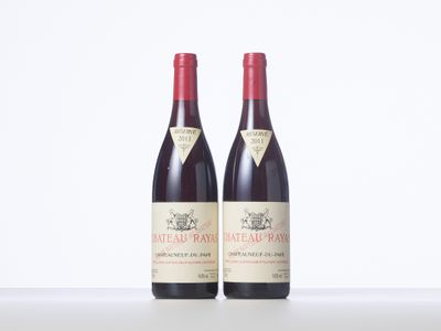 two bottles of red wine sitting next to each other on a table