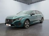 Une voiture verte est garée dans une grande pièce aux murs blancs.