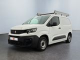 La camionnette blanche est garée dans une pièce au sol noir.