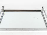 a metal tray with a mirror on top of it on a white surface