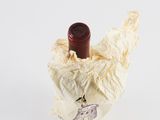 a wine bottle that is wrapped in a piece of paper