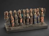 une sculpture représentant un groupe de personnes debout les unes à côté des autres