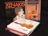 deux livres posés sur la table, à côté d'une guitare et d'un livre
