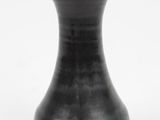 a black vase that is sitting on a white surface