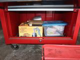 a red tool cart with a lot of items inside of it