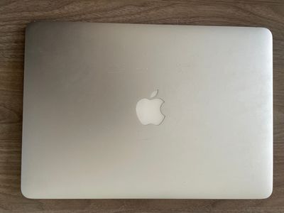 a white apple laptop sitting on a wooden table