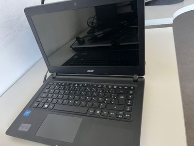 un ordinateur portable posé sur un bureau, à côté d'un écran