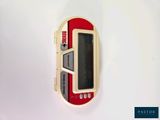 a red and white electronic device on a white surface