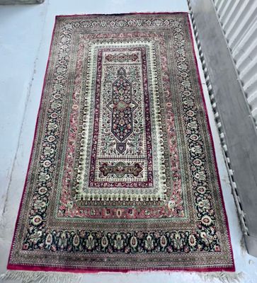 un tapis oriental sur une véranda, avec un berceau en arrière-plan