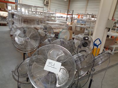 many fans that are on the floor in a warehouse