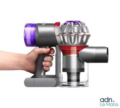 a close up of a person holding a small blow dryer in their hand