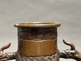 an image of a bronze vase with two elephants on it