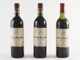 trois bouteilles de vin sont alignées sur une surface blanche