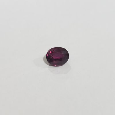 gros plan d'une pierre précieuse violette sur une surface blanche