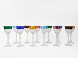 several different colored wine glasses are lined up in a row