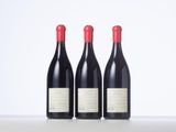 three bottles of red wine sitting on top of a table
