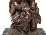 a statue of a woman holding a child on a marble base
