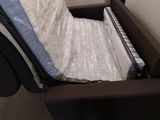 a couch that has a mattress on it in a warehouse