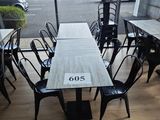 une table et des chaises dans une pièce avec beaucoup de fenêtres