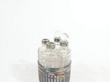 a small glass jar with a silver lid on a white surface