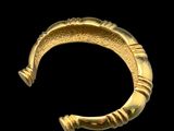 gros plan d'un bracelet en or sur fond noir