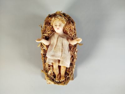 une petite figurine représentant l'Enfant Jésus dans un panier