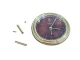 a clock that is sitting on a table next to some screws