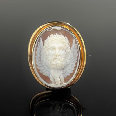 an antique carved shell cameo of a man with wings