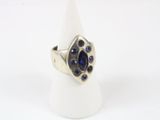 silver ring with blue stones on a white surface