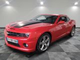 Une Chevrolet Camaro rouge est garée sur un sol à damier.