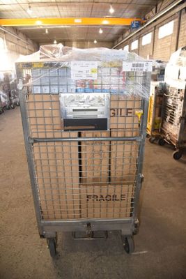a large metal cart with boxes on it in a warehouse