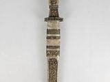 an old silver spoon with a handle on a white surface