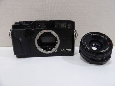 a black camera and a black lens on a white table
