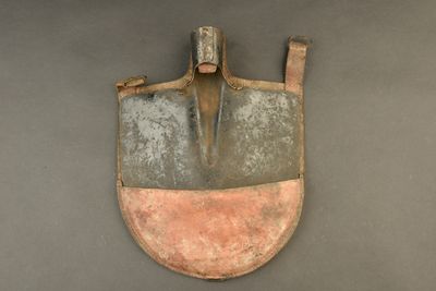 a small shovel with a long handle on the wall