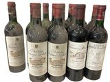 six bouteilles de vin sont alignées sur une surface blanche