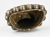 a gold shell shaped object on a white surface