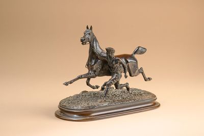 bronze statue of a horse and rider on a wooden base