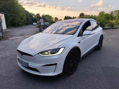 une Tesla Model X blanche garée sur un parking