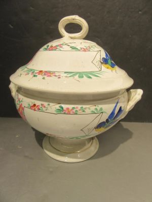 a white bowl with a lid and a handle on a table
