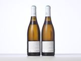 two bottles of white wine sitting on top of a table