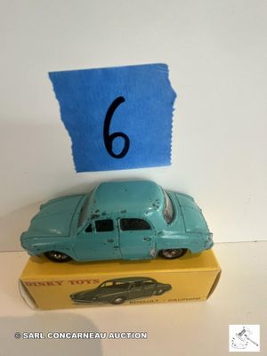 une petite voiture bleue posée sur une boîte jaune sur laquelle figure le chiffre 6