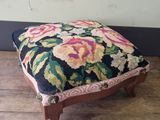 a small foot stool with a floral design on it