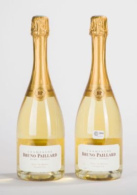 deux bouteilles de champagne posées l'une à côté de l'autre sur une table