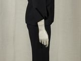 a mannequin dressed in a black suit and white gloves