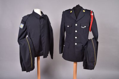 pair of military uniforms on mannequins on display against a gray background