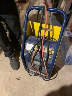un homme debout à côté d'une charrette contenant des fils électriques