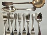 a lot of spoons, forks and spoons laid out on a table