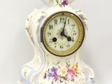 une petite horloge blanche ornée d'un motif floral